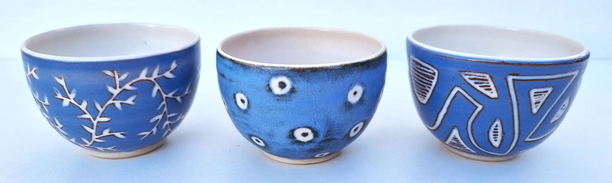 Trois bols bleus aux motifs gravés