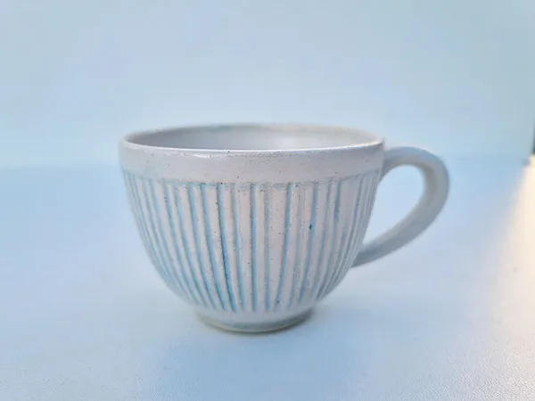 Tasse blanche à rayures bleues